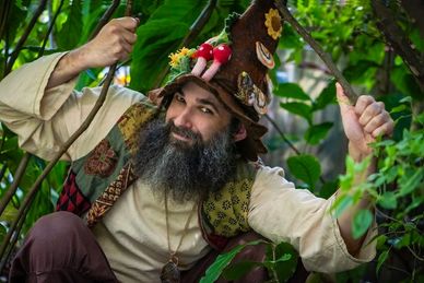 Man dressed as a whimsical forest character giving thumbs up.