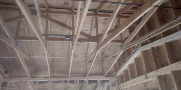 Exposed wooden ceiling framework of a building under construction.