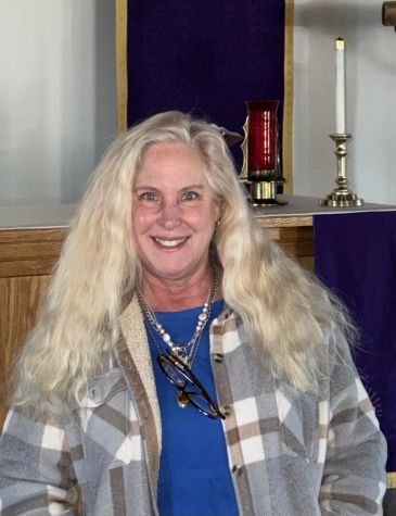 Smiling woman with long blonde hair in a checkered jacket.