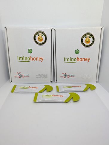 Two boxes and sachets of Iminohoney, a natural honey product.