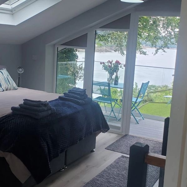 A bedroom with a private balcony on the side of Menai Strait