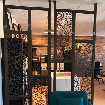 Decorative metal partition in an office setting.