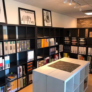 Organized office shelves with binders and magazines.