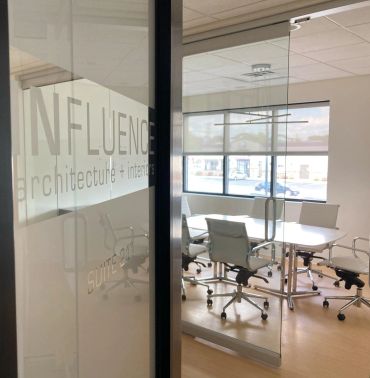 Modern conference room with glass walls and office chairs.
