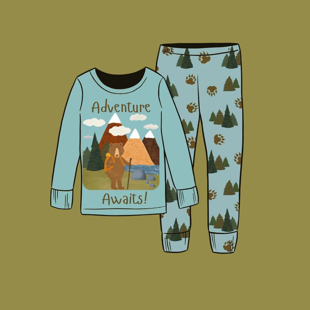 Children's pajama set with a bear hiking in the wilderness and trees and paw prints.