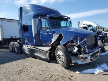 Blue semi-truck with front-end damage.