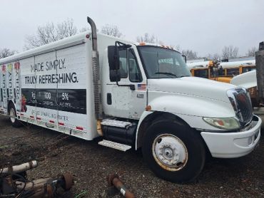 White delivery truck with beverage advertisement.