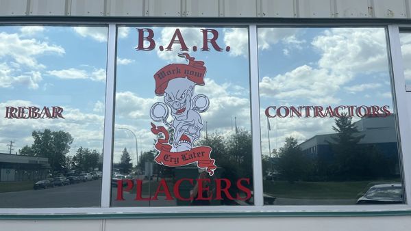 Reflective window with "B.A.R. Rebar Contractors Placers" and a monster logo.