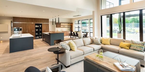 Spacious modern open-plan living room and kitchen with large windows.