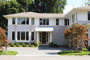 Front yard idea with Maple trees and paved driveway with cobblestone and peastones for drainage