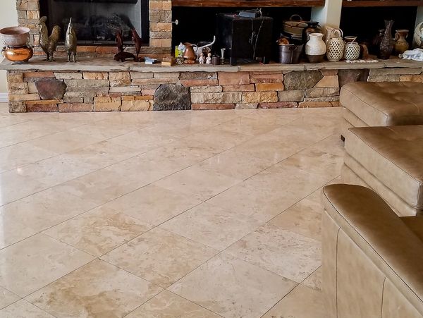 Polished travertine in living room with stone fireplace