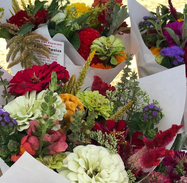 Colorful flower bouquets wrapped in white paper.