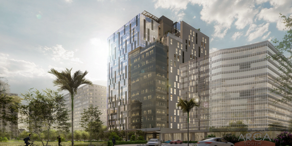 Modern glass office buildings with palm trees and moving cars on a sunny day.