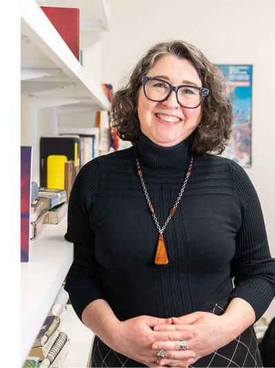 Photo of Crawford standing by bookshelf.