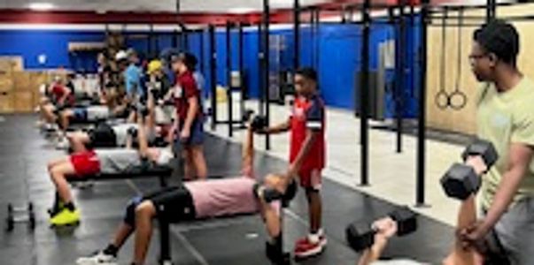 A group of people working out with dumbbells in a gym.