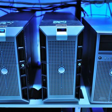 Three computer servers with blue lighting in a data center.