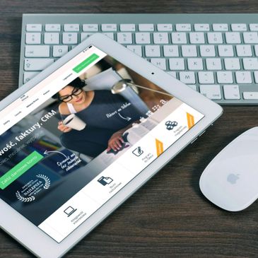 Tablet displaying a business software interface beside a keyboard and mouse.