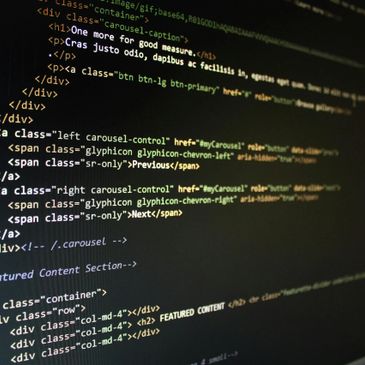 Close-up of HTML code on a screen showing web page structure and navigation controls.