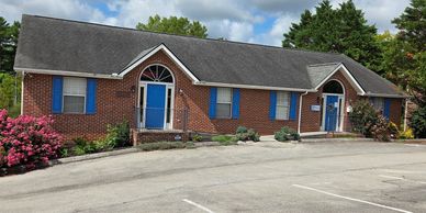 Brick building with blue doors and window shutters.
