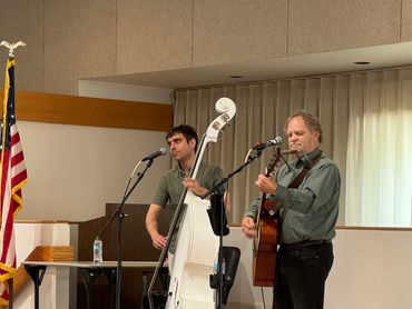 Two musicians performing on stage with a double bass and guitar.