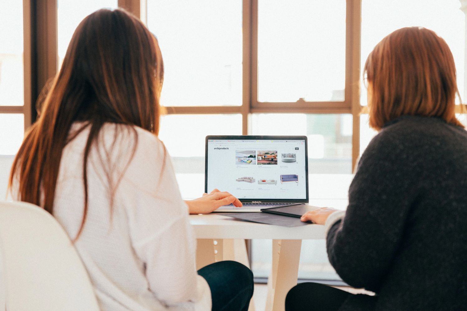 Two women look at information on a laptop screen