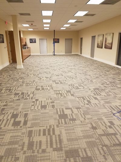 Empty room with patterned carpet and ceiling lights.