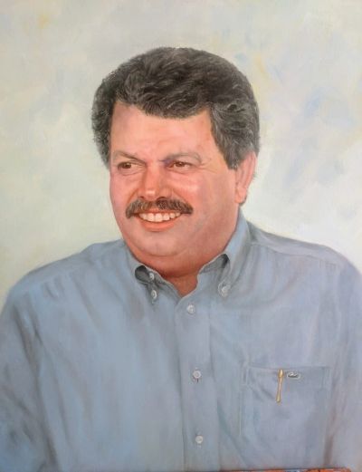 Retrato de homem sorridente de cabelo grisalho e bigode.