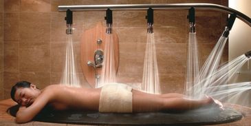 Woman enjoying a multi-jet water massage in a spa.