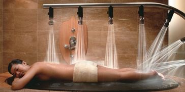 Woman enjoying a multi-jet water massage in a spa.