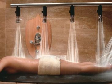 Woman enjoying a multi-jet water massage in a spa.