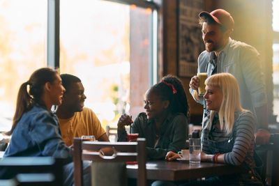 Friends enjoying drinks and conversation in a cozy cafe.