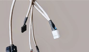 Close-up of several white electrical cables with black and white connectors.