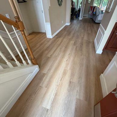Bright, spacious hallway with light wood flooring and white trim.