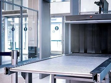 Airport security conveyor belt and scanner for luggage screening.