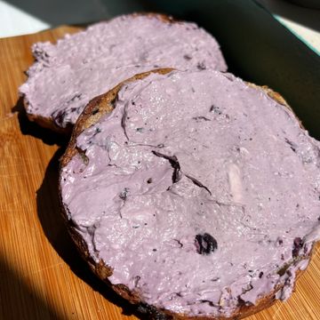 Bagel halves with purple cream spread.