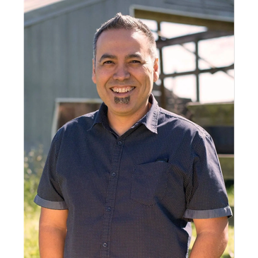 Smiling man outdoors in a casual shirt.
