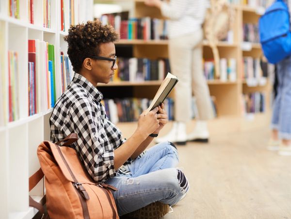 Young black male reading a book 