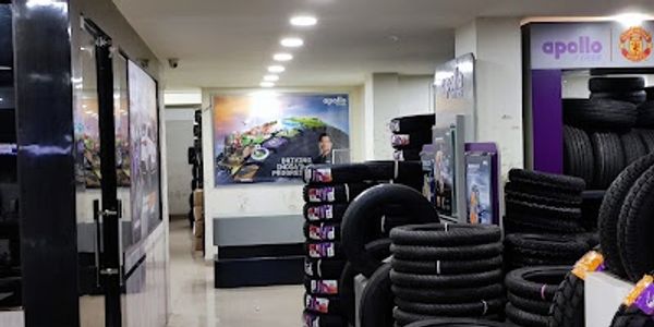 Interior of a tire shop with stacks of tires and bright ceiling lights.
