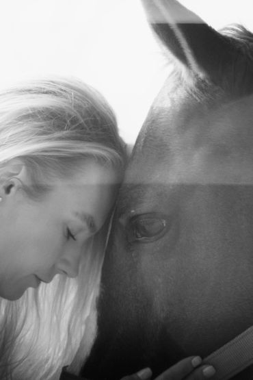 Mujer y caballo conectando con la frente apoyada.