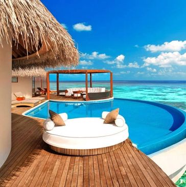 A luxurious overwater villa with a private pool overlooking clear turquoise ocean waters.