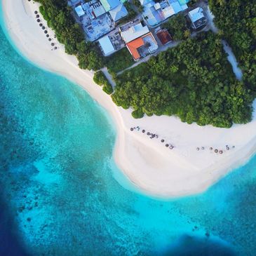 Aerial view of a tropical island with white sandy beach and turquoise water.