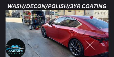Red car being detailed at a car wash station.