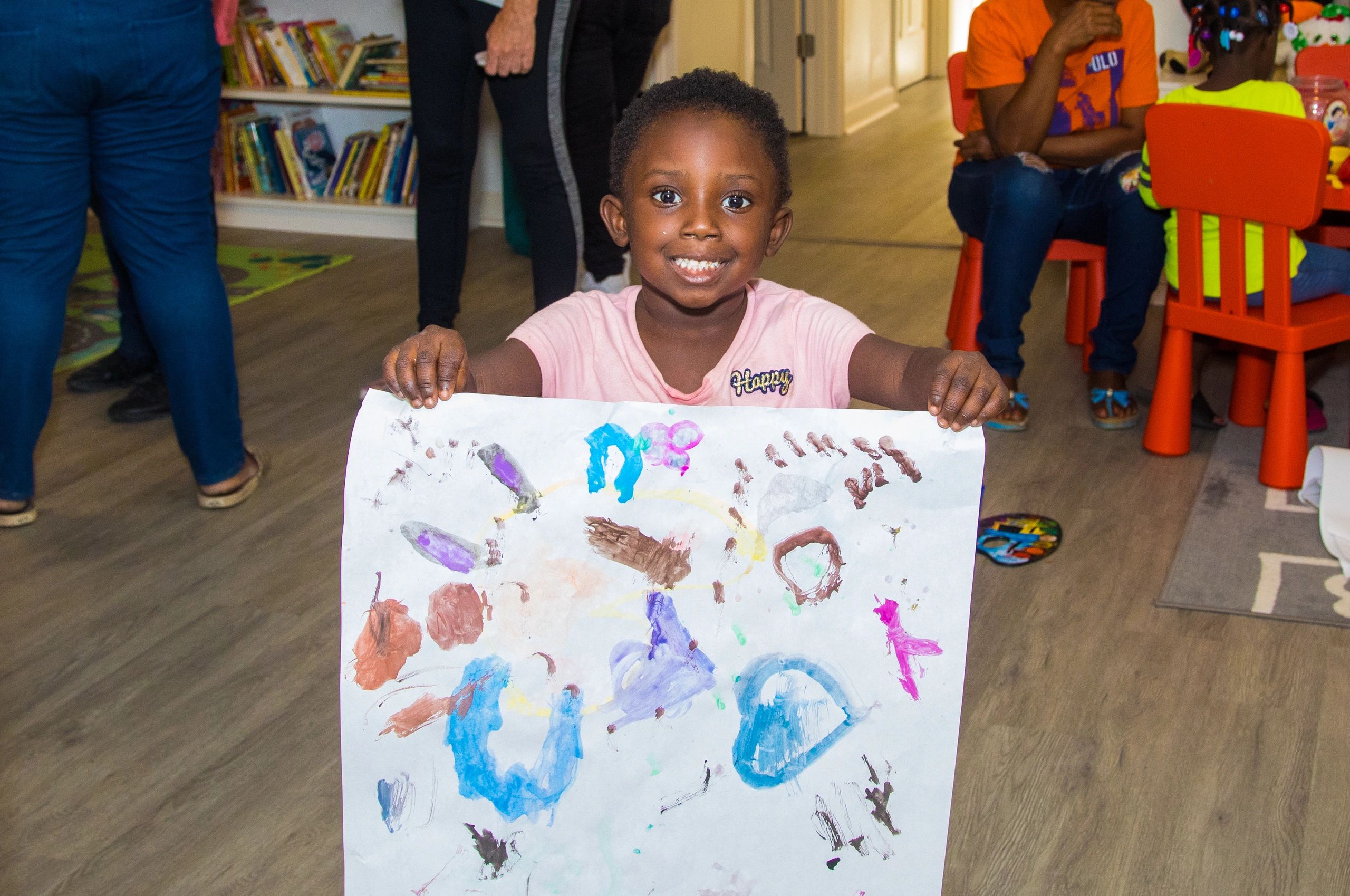 A child holding up a finger painting