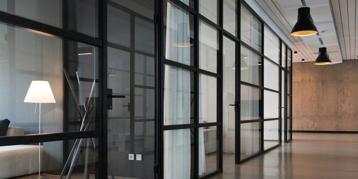 Modern Office design with glass partitions, and polished concrete finishing on the floor  