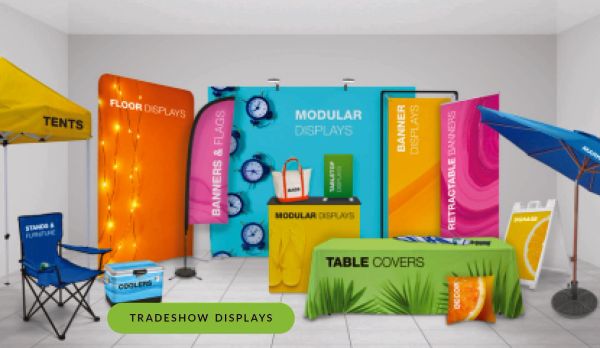Group of printed tradeshow display items: flag, backdrop banner, roll up banners, SEG display, tent 