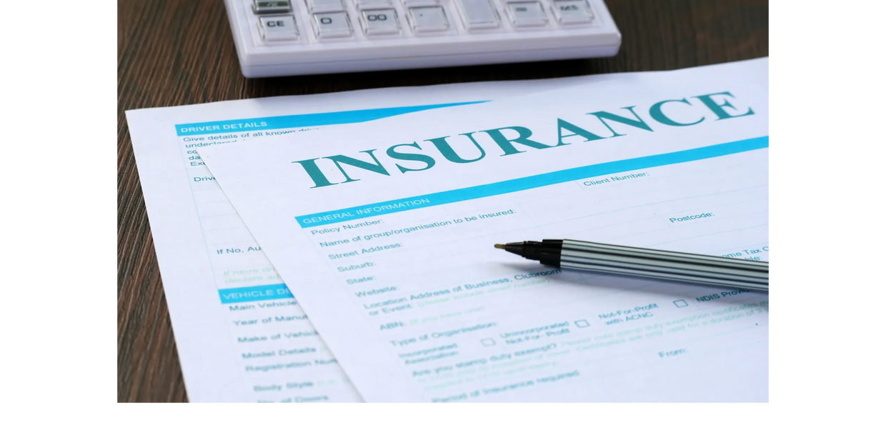 Insurance reimbursement documents with a pen and calculator on a wooden table.