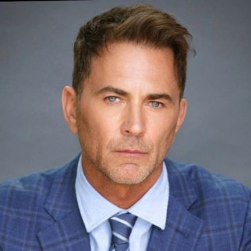 Portrait of a serious man in a blue suit and tie.