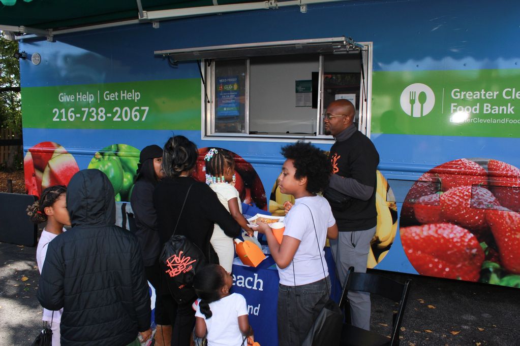 People gather at a Greater Cleveland Food Bank truck for food assistance.