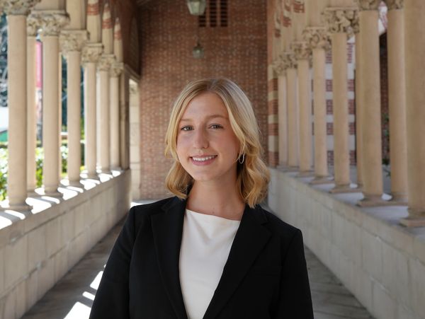 Young woman smiling in a corridor with columns.
