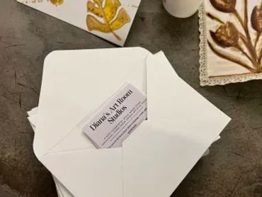 Business card placed on white envelopes on a table.